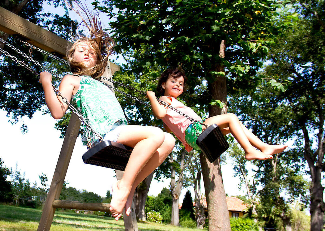 Two children on wooden swing set